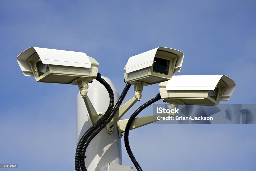 Three surveillance cameras against a blue sky Security cctv cameras Analyzing Stock Photo