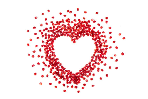 istock Pomegranate seeds in heart shape, white background, copyspace 916159250