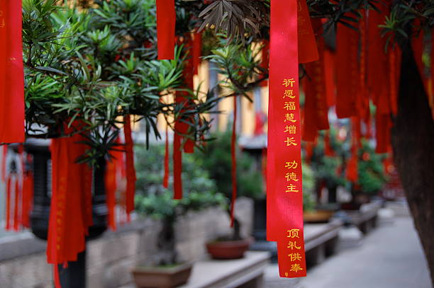 Chinese prayer ribbons hanging from bonsai trees stock photo
