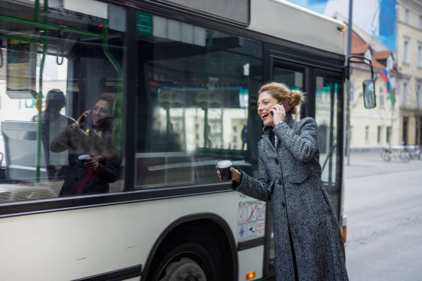 istock Woman using smart phone and waiting at the bus station 916160740
