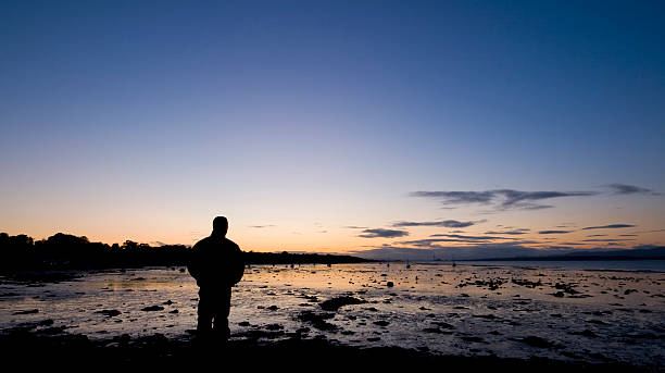 istock Silhouette person looking over bay at sunset. 91616124