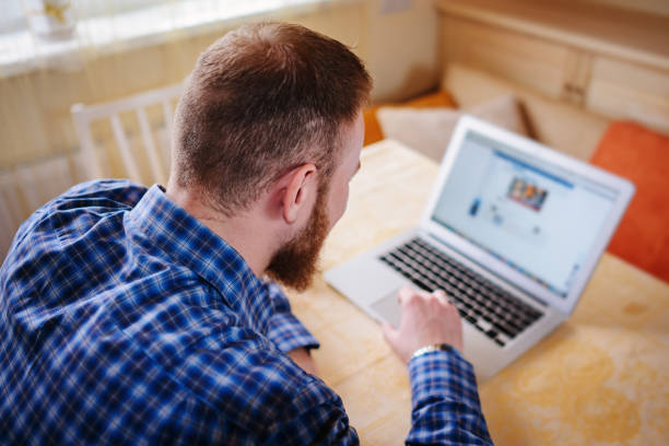 istock businessman using laptop at workplace - rear view 916164756