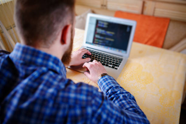 istock businessman using laptop at workplace - rear view 916164796