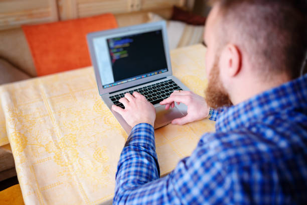 istock businessman using laptop at workplace - rear view 916164842