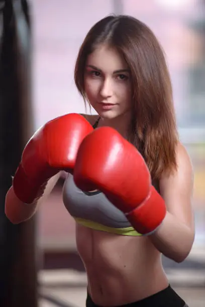 Photo of Attractive Female Punching A Bag With Boxing Gloves On