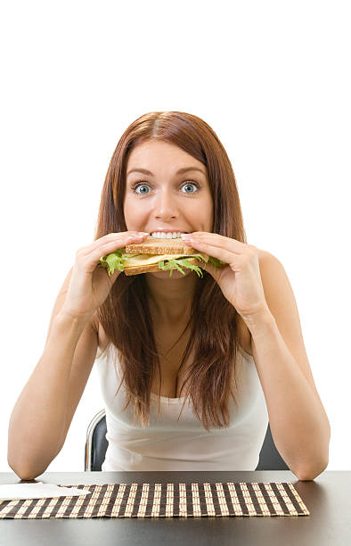 Very hungry gluttonous woman eating sandwich with cheese, isolated stock photo