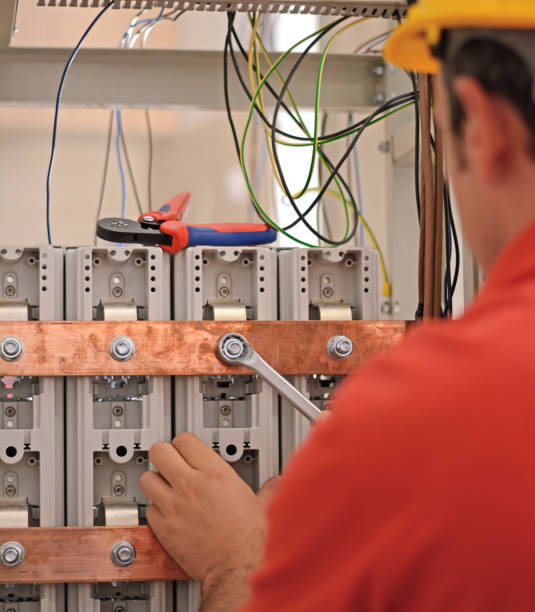 istock Electrician at work. Man holding wrench and working on equipment. 916171888