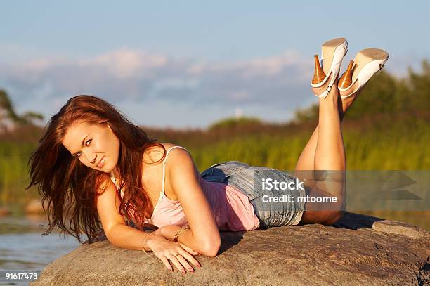 Menina Adolescente Pôr Em Uma Pedra - Fotografias de stock e mais imagens de Mulheres - Mulheres, Adolescente, Adulto