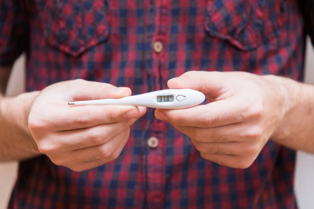 istock Man holding an electric thermometer 916175964