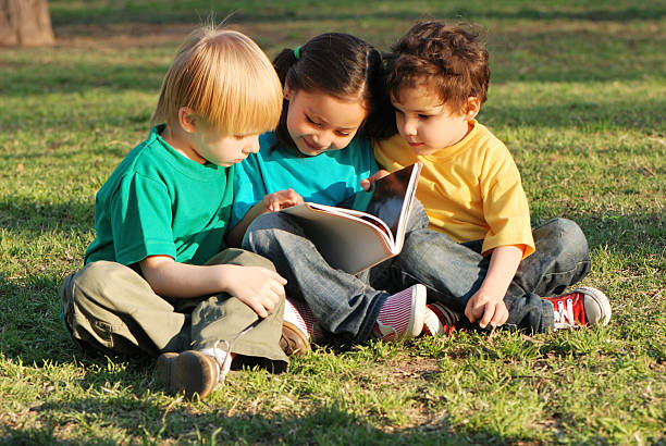 istock Group of children with the book on a grass 91618178