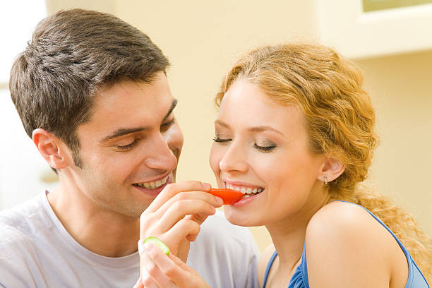 istock Young amorous couple eating vegetables together at home 91618360