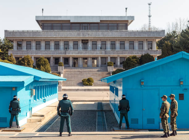 Demilitarized Zone, South Korea - Soldiers facing each other across the border between the two countries, with South Korean soldiers in the foreground, and a North Korean soldier in the distance.