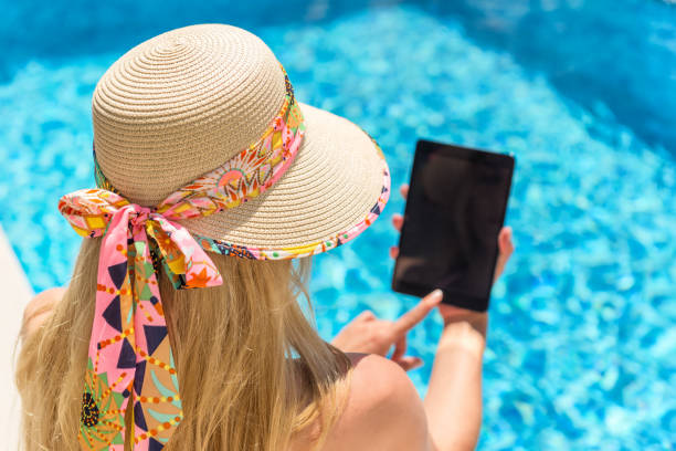 istock Woman working on tablet by pool 916185948