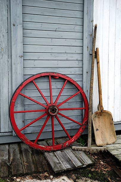 istock Red wooden wheel against a barn wall 91619279