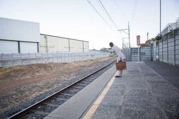 A woman on foot on a railroad track facing the journey ahead.