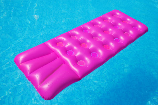 istock Pink air mattress on a swimming pool tropical 916197176