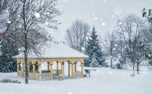 A pavilion in a park during a snowstorm at the end of the day. Big snowflakes in the foreground. Parc de la Seigneurie de Ramezay in Saint-Hugues, Quebec.