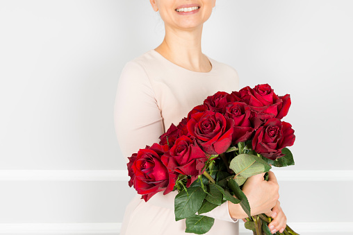Woman holding red roses.