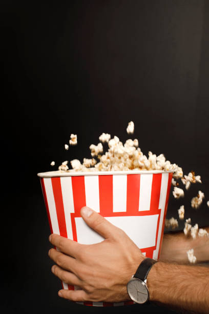 istock man holding bucket of popcorn 916208586