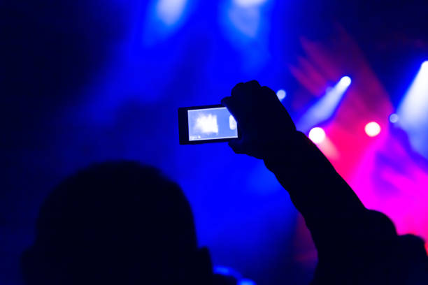 istock taking photo video mobile phone silhouettes crowd 916209584