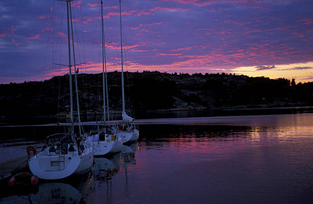 Colorful painting of anchored yachts at misty morning on the lake on mountains background