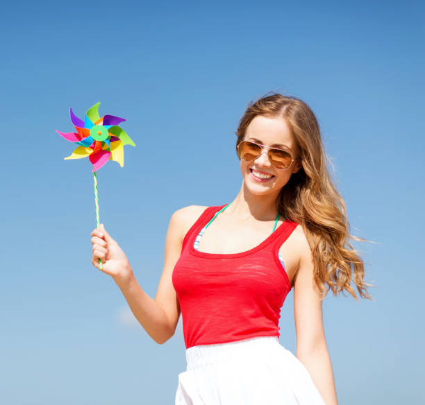istock girl with windmill toy on the beach 916212098