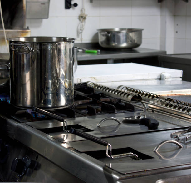 istock Large steel professional pan on the stove with fire in restaurant kitchen 916212906