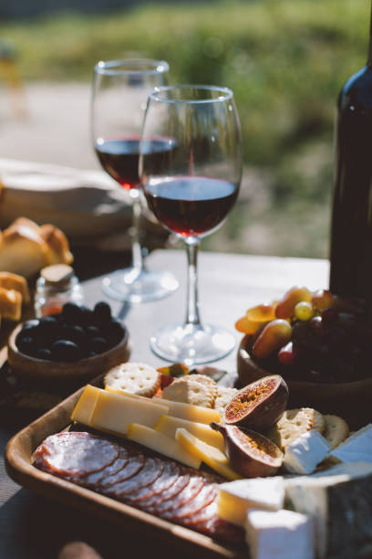 istock wine with wooden plate of sliced snacks 916219082