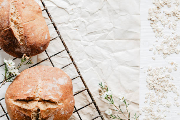 Traditional Irish soda bread made for St. Patrick's Day with little white flowers and oats on white wooden table
