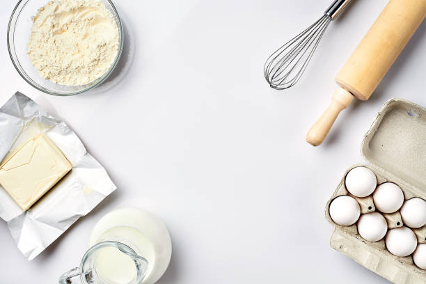 preparation of the dough. ingredients for the dough - flour, butter, eggs and various tools. on white background. free space for text . top view - baking flour ingredient animal egg imagens e fotografias de stock