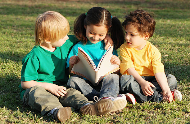 istock Group of children with the book on a grass 91622196