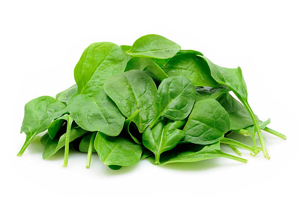 Pile of baby spinach leaves on white Young spinach leaves in isolated white background spinach stock pictures, royalty-free photos & images