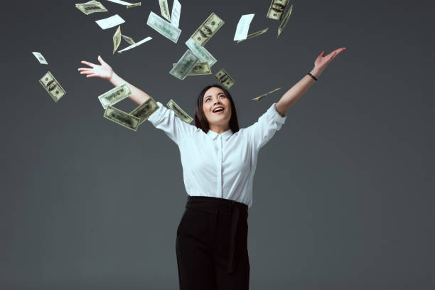 istock smiling young woman throwing dollar banknotes 916223936