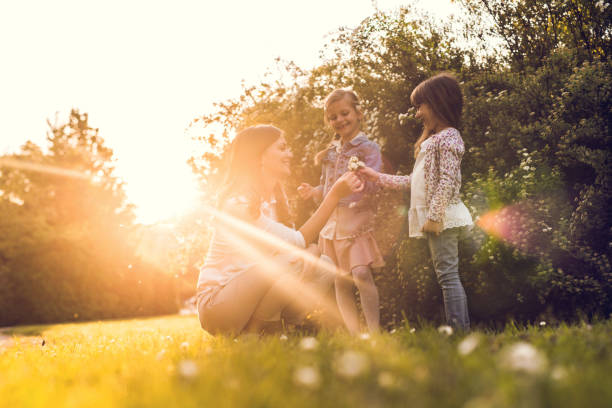 giornata di sole con madre e figlie - mothers day mother single flower family foto e immagini stock