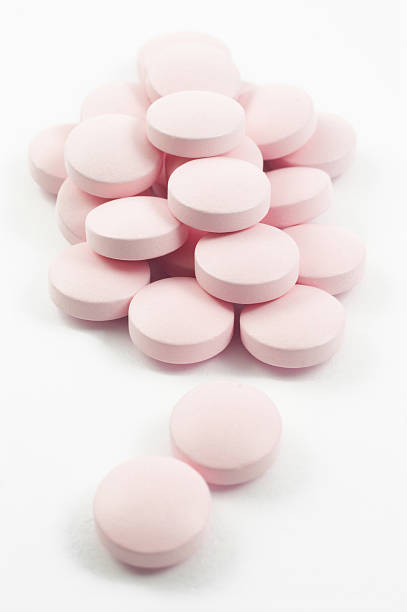 istock pink tablets and pills isolated on white 91622513