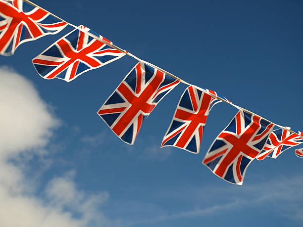 Flags at fete, shot with telephoto lens fluttering in summer breeze.         