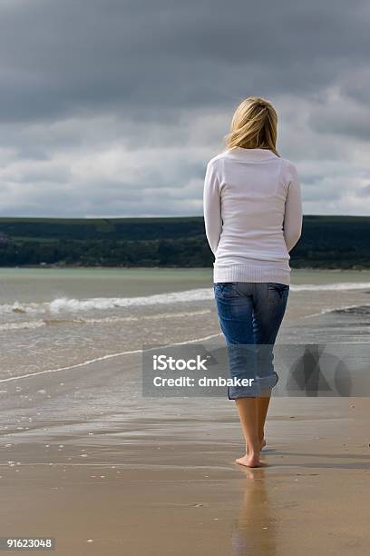 Rear View Of Woman On A Beach With Stormy Skies Stock Photo - Download Image Now - Adult, Adults Only, Beach