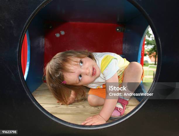 Bambina Giocando In Un Parco Giochi Per Bambini Mädchen Auf Kinderspielplatz - Fotografie stock e altre immagini di Guardare fuori dalla finestra