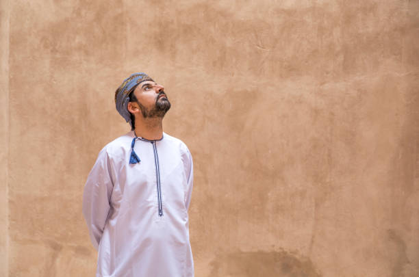 arab man in traditional omani outfit arab man in traditional omani outfit looking up arabian sea photos stock pictures, royalty-free photos & images