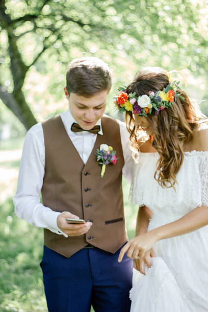 istock Wedding couple smiling while looking to the smartphone 916242656