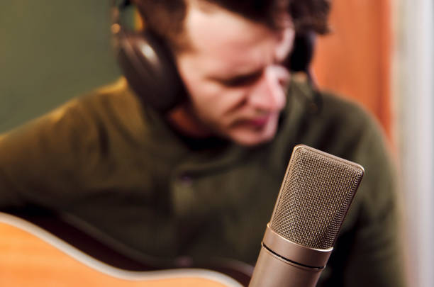 istock Man in music studio playing guitar 916242736