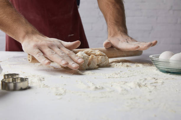 istock cropped image of chef rolling dough with rolling pin 916242818