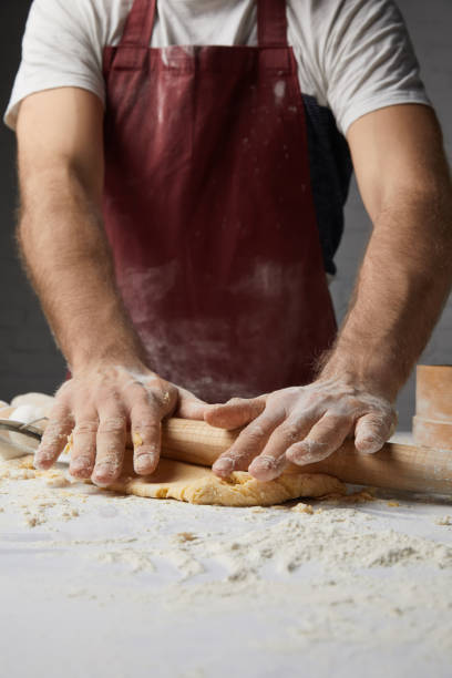 istock cropped image of chef kneading dough with rolling pin 916242892