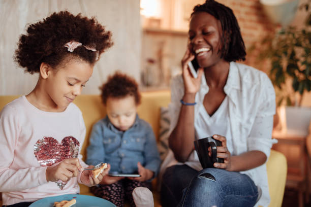 istock Happy mom speaking on the phone while her children are having breakfast 916245230