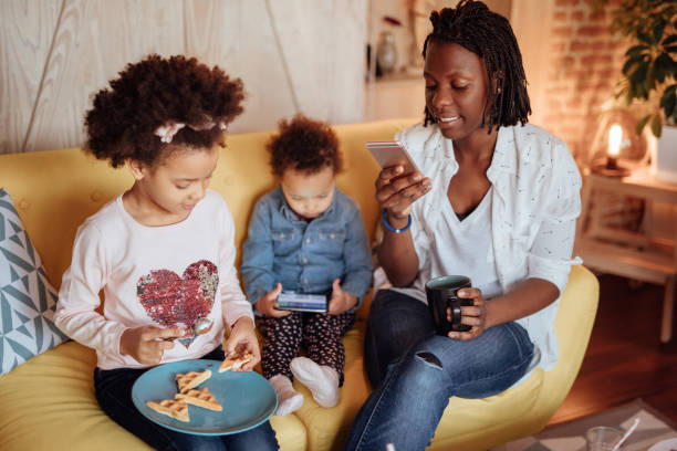 istock Mom reading text messages while her kids sits next to her 916245410