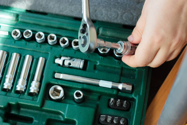 istock Hand with socket wrench with the socket wrench kit in a background. 916245572