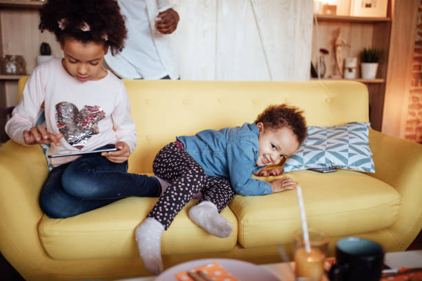 istock Two little girls playing on the sofa 916249450