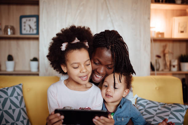istock Mom hugging her kids while watching videos online and singing 916249482
