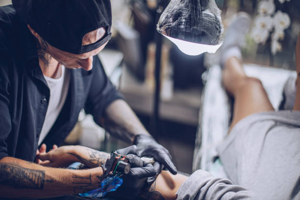 istock Man tattoo artist working 916249562