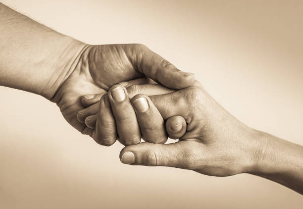 donner un coup de main - assistance holding hands friendship human hand photos et images de collection